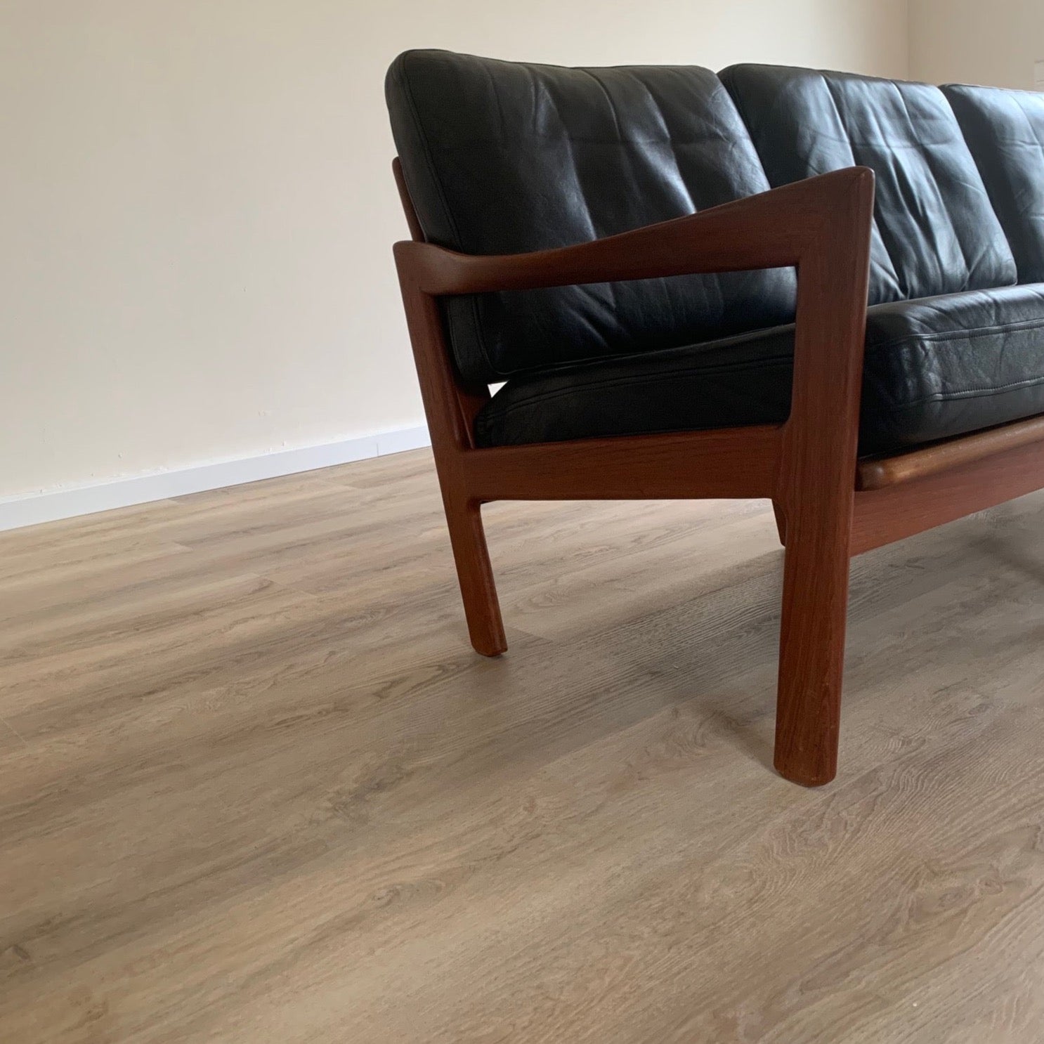 Skandinavisches Wohnzimmer mit Holzoptik Vinylboden – stilvoller Bodenbelag und Retro-Ledersofa
