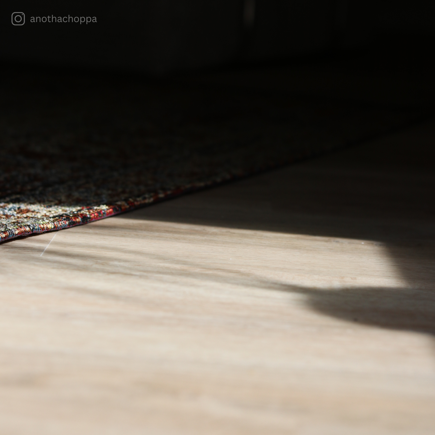 Detailaufnahme des Klebevinyls Eiche Mirandus in heller Holzoptik mit orientalischem Teppich und sanftem Lichteinfall – stilvoller Vinylboden von Laminatshop24